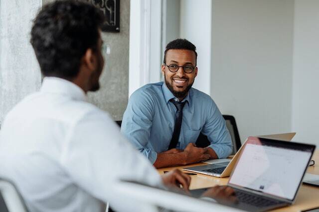 a property manager in a white shirt and another in a blue shirt having a meeting